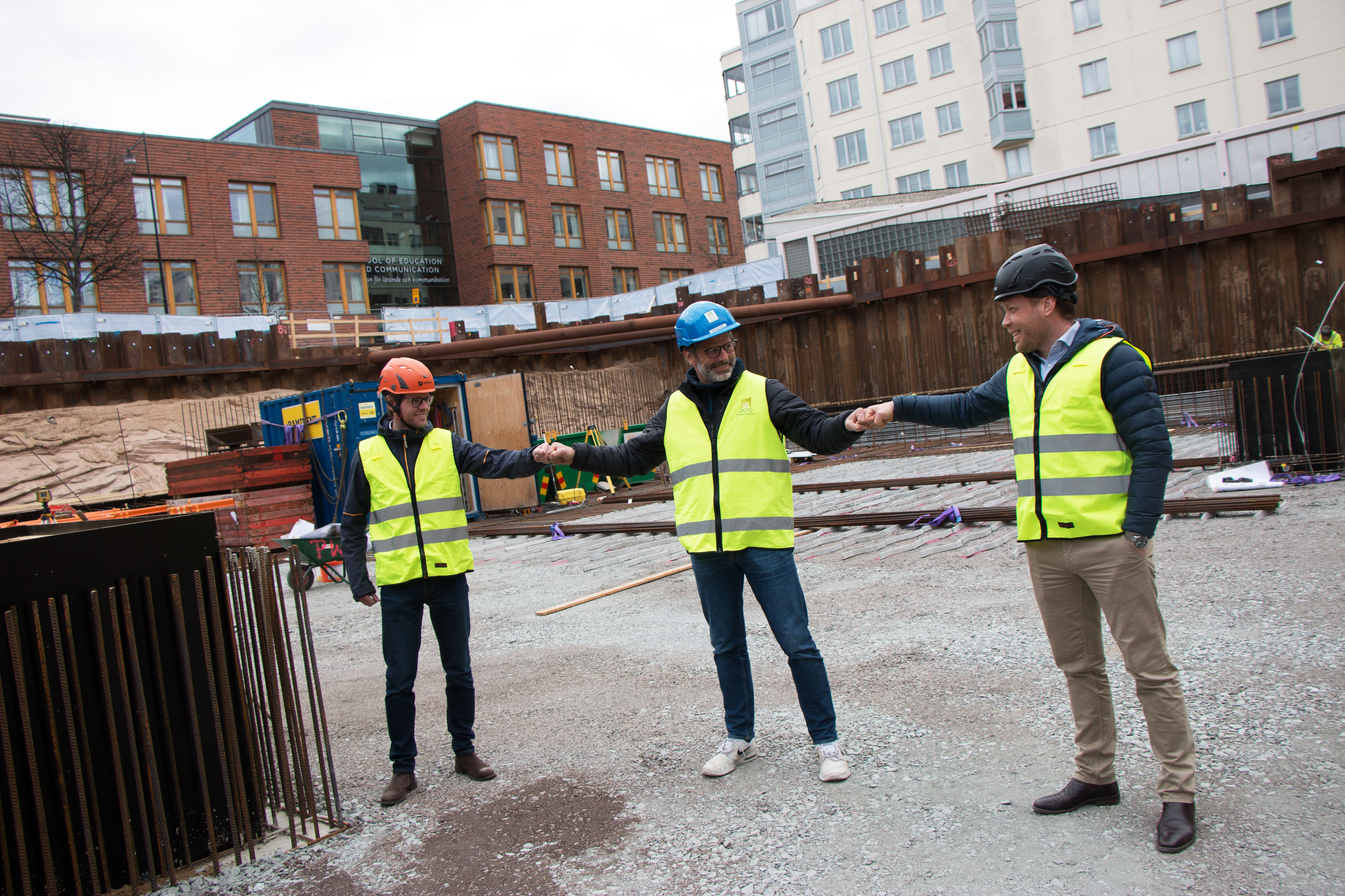 Gustav Österström (VD Science Park), Magnus Olsson (VD JKPG Fast) och Dan Friberg (VD Infobric) gör en fist bump med varandra i vad som snart kommer att vara Science Park Towers.