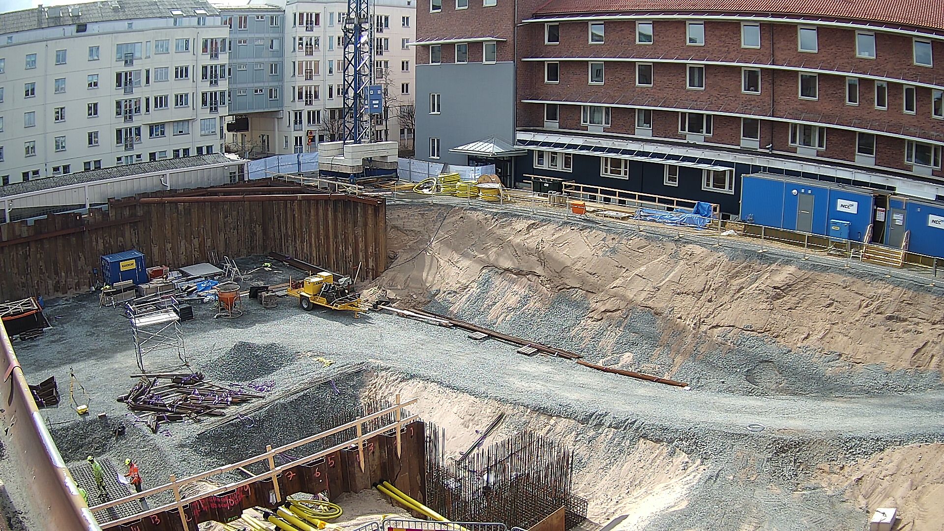 Byggarbetsplatsen sett från nuvarande hus 01 med nuvarande Science Park House i bakgrunden. Byggmaterial och arbetare är på plats och arbetar.