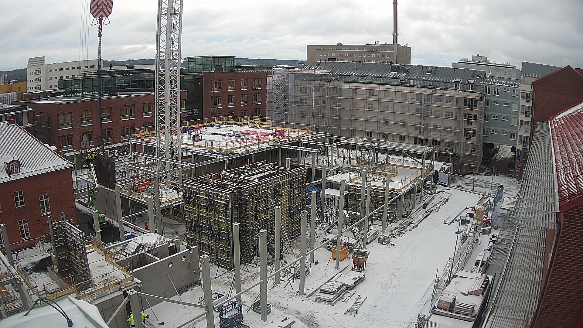 Byggarbetsplatsen 2021-12-02 sett från taket på nuvarande Science Park house. Årets första snö har lagt sig över bygget.