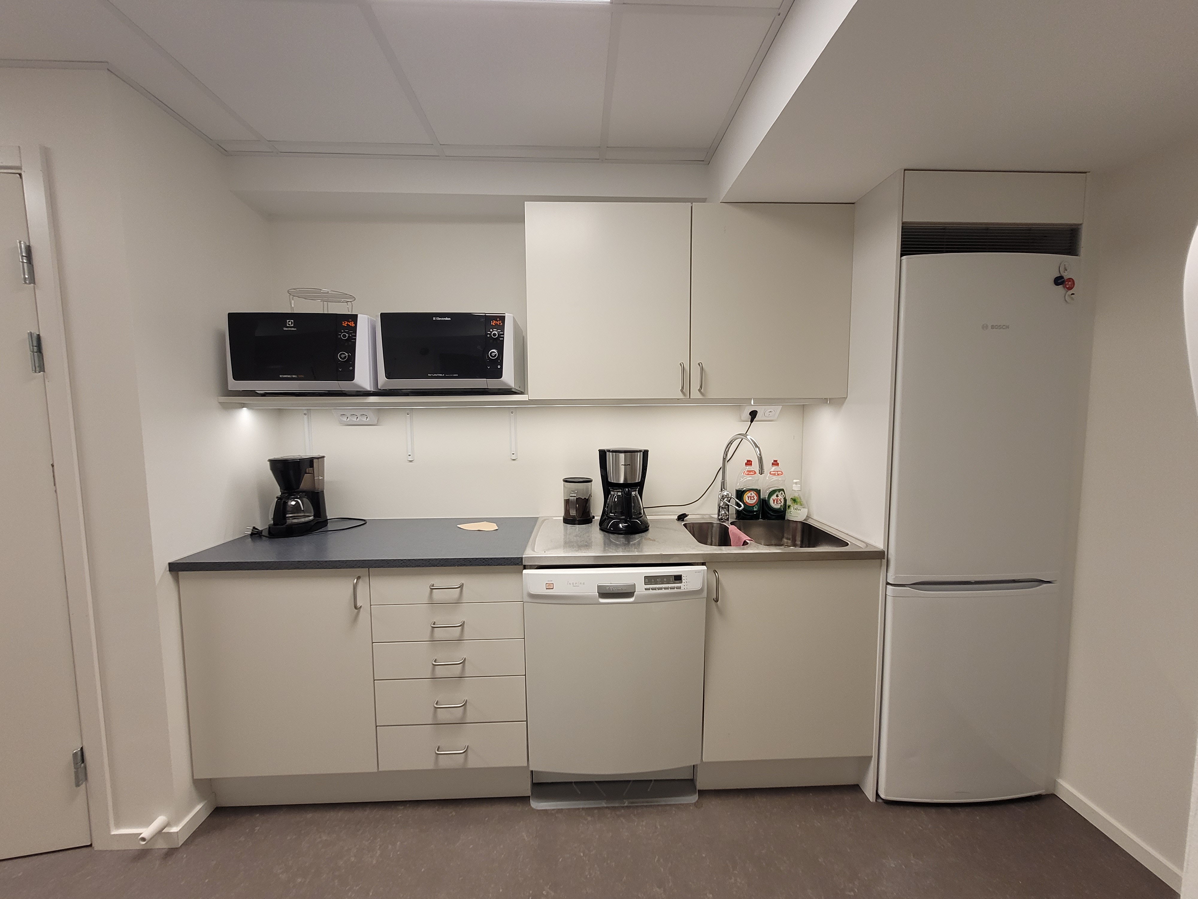 Det nya köket i entreprenörsrummet. Diskbänk, vita skåpsluckor, micros, kaffebryggare mm.