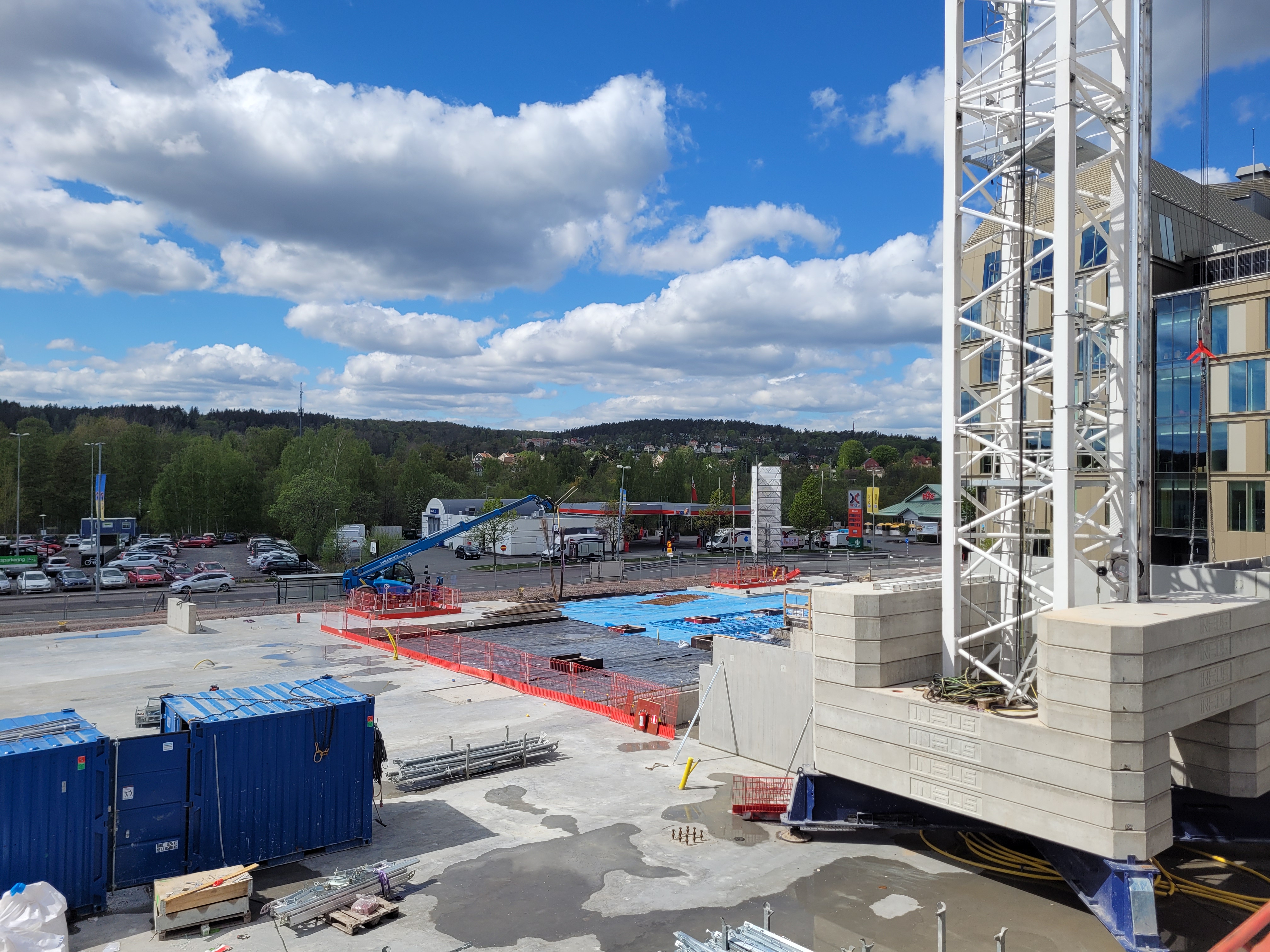 Byggarbetsplatsen sett från blivande förskolans innergård med blick över den blivande matbutiken och gymmet, med Jordbrovägen i bakgrunden.